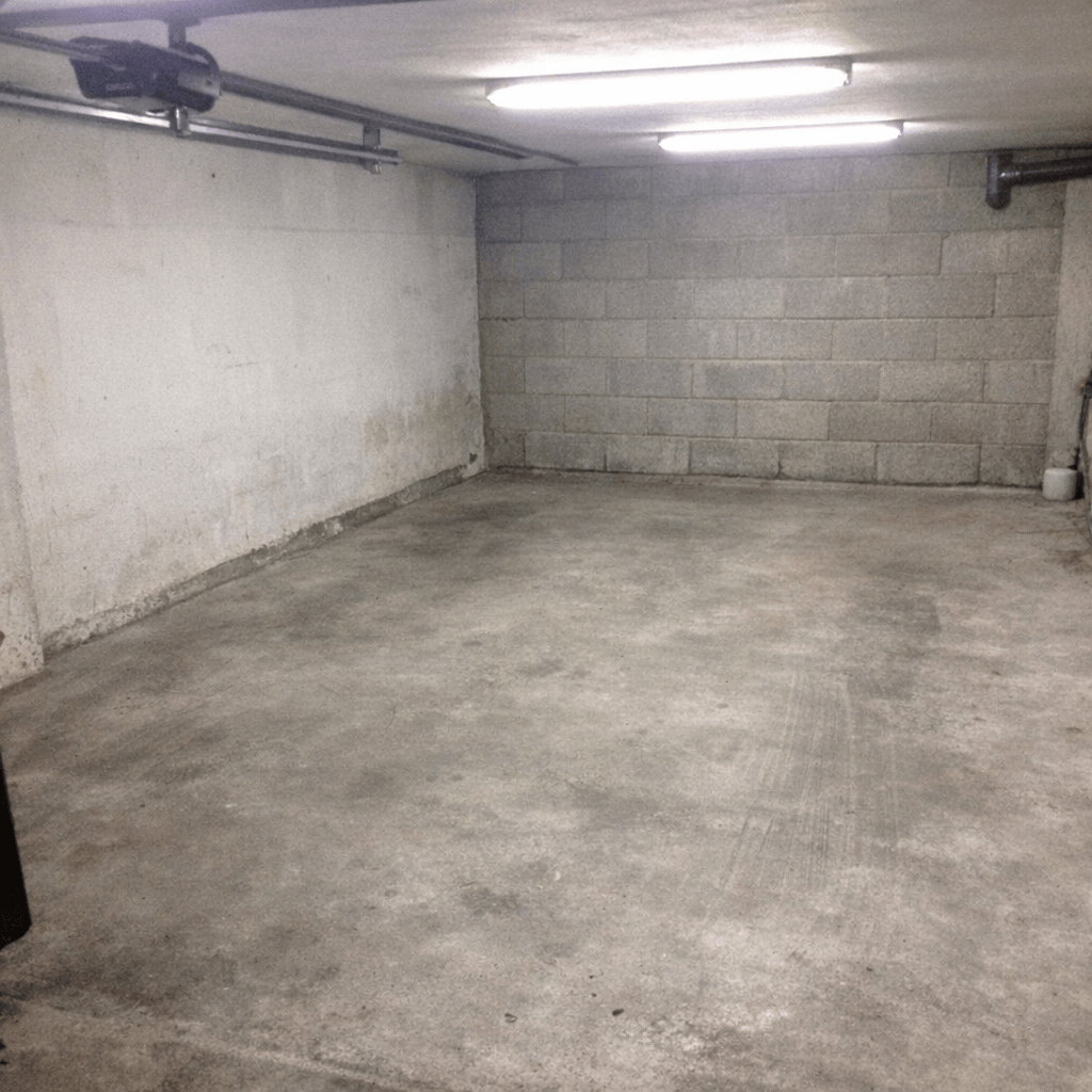 Leere Garage mit gereinigtem Boden und sortierten Reststoffen am Rand zur Abholung